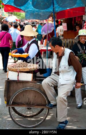 China: Erdnussverkäufer in der Nähe des Vogel- und Blumenmarktes im alten muslimischen Viertel an der Jingxing Road an der Zheng Yi Road, Kunming, Provinz Yunnan. Kunming wurde am Ufer des Dian-Sees erbaut und von Kalksteinbergen umgeben, und war eine wichtige alte Handelsroute zwischen Tibet, China und Südostasien. Die Stadt, damals Yunnanfu genannt, litt unter den Händen des Rebellenführers du Wenxiu, des Sultans von Dali, der die Stadt zwischen 1858 und 1868 mehrmals attackierte und belagerte und die meisten buddhistischen Tempel der Stadt zerstörte. Stockfoto