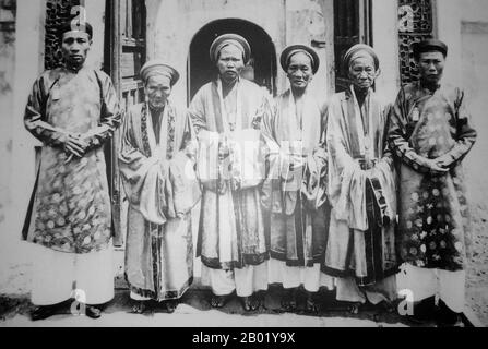 Vietnam: Eunuchen und Palastmädchen in der Verbotenen Stadt in Hue, um 1930. Die Kaiserstadt (Vietnamesisch Kinh thành Huế) in Huế ist eine ummauerte Festung und ein Palast in der ehemaligen Hauptstadt Vietnams. Das Gelände der Reichsstadt war von einer Mauer von zwei Kilometern mal zwei Kilometern umgeben, die Mauern von einem Graben umgeben. Das Wasser aus dem Graben stammt aus dem Song Huong (Parfümfluss), der durch Huế fließt. Diese Struktur wird Zitadelle genannt. Im Inneren der Zitadelle befindet sich die kaiserliche Stadt mit einem Umkreis von fast 2,5 Kilometern. Stockfoto