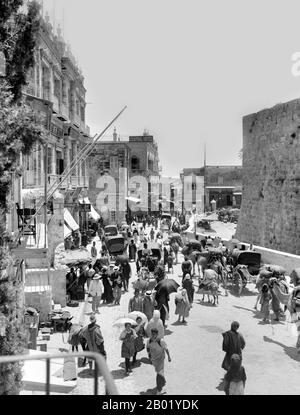 Palästina: Eine Menge palästinensischer Fußgänger im Inneren des Jaffa-Tors in Jerusalem, die nach Osten schauen, ca. 1920. Palästina ist ein Name für die geografische Region zwischen dem Mittelmeer und dem Jordan. Die Region ist auch als das Land Israel, das Heilige Land und die Südlevante bekannt. 1832 wurde Palästina von Mohammed Alis Ägypten erobert, aber 1840 intervenierte Großbritannien und gab die Kontrolle über die Levante an die Osmanen zurück, als Gegenleistung für weitere Kapitulationen. Am Ende des 19. Jahrhunderts begann die zionistische Einwanderung und die Wiederbelebung der hebräischen Sprache. Stockfoto