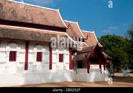 Thailand: Altes Viharn, Wat Hang Dong, Chiang Mai, Nordthailand. Wat Hang Dong ist ein typisches Beispiel für die traditionelle Tempelarchitektur von Lanna. Der alte Viharn in diesem Tempel ist etwas aufwändiger als sein Gegenstück im nahe gelegenen Wat Ton Kwen, ist aber in Form, Stil und Aussehen im Wesentlichen ähnlich. Auch dunkel und intim, mit einem niedrigen, geschwungenen, dreistöckigen Dach, beherbergt der Viharn eine Sammlung von Buddha-Bildern, von denen mindestens zwei – rechts und links vom Hauptbild des Buddha – im Stil von Lao und doch irgendwie seltsam primitiv sind. Stockfoto