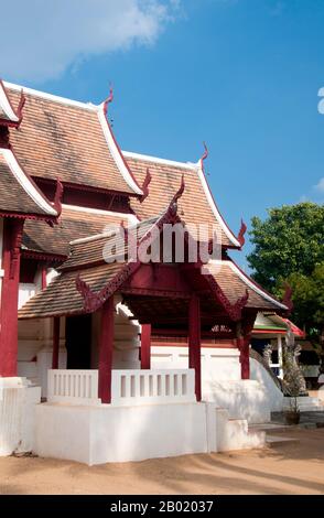 Thailand: Altes Viharn, Wat Hang Dong, Chiang Mai, Nordthailand. Wat Hang Dong ist ein typisches Beispiel für die traditionelle Tempelarchitektur von Lanna. Der alte Viharn in diesem Tempel ist etwas aufwändiger als sein Gegenstück im nahe gelegenen Wat Ton Kwen, ist aber in Form, Stil und Aussehen im Wesentlichen ähnlich. Auch dunkel und intim, mit einem niedrigen, geschwungenen, dreistöckigen Dach, beherbergt der Viharn eine Sammlung von Buddha-Bildern, von denen mindestens zwei – rechts und links vom Hauptbild des Buddha – im Stil von Lao und doch irgendwie seltsam primitiv sind. Stockfoto