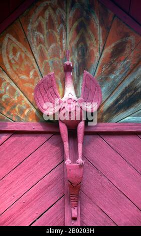 Thailand: Pfauendetails über den alten Viharn, Wat Hang Dong, Chiang Mai, Nordthailand. Wat Hang Dong ist ein typisches Beispiel für die traditionelle Tempelarchitektur von Lanna. Der alte Viharn in diesem Tempel ist etwas aufwändiger als sein Gegenstück im nahe gelegenen Wat Ton Kwen, ist aber in Form, Stil und Aussehen im Wesentlichen ähnlich. Auch dunkel und intim, mit einem niedrigen, geschwungenen, dreistöckigen Dach, beherbergt der Viharn eine Sammlung von Buddha-Bildern, von denen mindestens zwei – rechts und links vom Hauptbild des Buddha – im Stil von Lao und doch irgendwie seltsam primitiv sind. Stockfoto