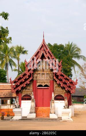 Thailand: Altes Viharn, Wat Hang Dong, Chiang Mai, Nordthailand. Wat Hang Dong ist ein typisches Beispiel für traditionelle LAN Na Tempelarchitektur. Der alte Viharn in diesem Tempel ist etwas aufwändiger als sein Gegenstück im nahe gelegenen Wat Ton Kwen, ist aber in Form, Stil und Aussehen im Wesentlichen ähnlich. Auch dunkel und intim, mit einem niedrigen, geschwungenen, dreistöckigen Dach, beherbergt der Viharn eine Sammlung von Buddha-Bildern, von denen mindestens zwei – rechts und links vom Hauptbild des Buddha – im Stil von Lao und doch irgendwie seltsam primitiv sind. Stockfoto