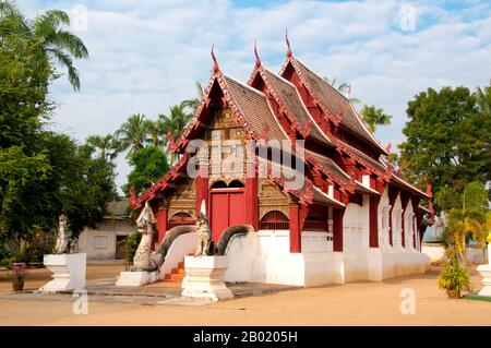 Thailand: Altes Viharn, Wat Hang Dong, Chiang Mai, Nordthailand. Wat Hang Dong ist ein typisches Beispiel für traditionelle LAN Na Tempelarchitektur. Der alte Viharn in diesem Tempel ist etwas aufwändiger als sein Gegenstück im nahe gelegenen Wat Ton Kwen, ist aber in Form, Stil und Aussehen im Wesentlichen ähnlich. Auch dunkel und intim, mit einem niedrigen, geschwungenen, dreistöckigen Dach, beherbergt der Viharn eine Sammlung von Buddha-Bildern, von denen mindestens zwei – rechts und links vom Hauptbild des Buddha – im Stil von Lao und doch irgendwie seltsam primitiv sind. Stockfoto