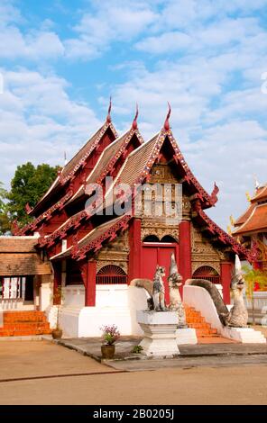 Thailand: Altes Viharn, Wat Hang Dong, Chiang Mai, Nordthailand. Wat Hang Dong ist ein typisches Beispiel für traditionelle LAN Na Tempelarchitektur. Der alte Viharn in diesem Tempel ist etwas aufwändiger als sein Gegenstück im nahe gelegenen Wat Ton Kwen, ist aber in Form, Stil und Aussehen im Wesentlichen ähnlich. Auch dunkel und intim, mit einem niedrigen, geschwungenen, dreistöckigen Dach, beherbergt der Viharn eine Sammlung von Buddha-Bildern, von denen mindestens zwei – rechts und links vom Hauptbild des Buddha – im Stil von Lao und doch irgendwie seltsam primitiv sind. Stockfoto