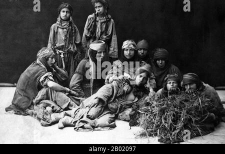 Palästina: Eine Gruppe von Beduinenfrauen. Foto von Tancrède R. Dumas (1830-1905), ca. 1860-1900. Beduinen sind Teil einer überwiegend in der Wüste lebenden arabischen ethnischen Gruppe, die traditionell in Stämme oder Clans unterteilt ist, die auf Arabisch als ʿašāʾir bekannt sind. Der Begriff Beduin leitet sich von einer Pluralform des arabischen Wortes badawī ab, wie es in umgangssprachlichen Dialekten ausgesprochen wird. Der arabische Begriff badawī leitet sich vom Wort bādiyah ab, was semiaride Wüste bedeutet (im Gegensatz zu ṣaḥarāʾ, was Wüste bedeutet). Ab dem späten 19. Jahrhundert begannen viele Beduinen unter britischer Herrschaft in ein seminomadisches Leben zu übergehen. Stockfoto