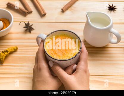 Frau hält heißes gesundes Getränk mit Gewürzen in der Tasse Stockfoto