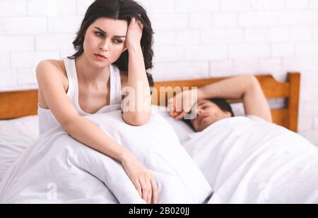 Eine tausendjährige Frau kann nicht im Bett in der Nähe eines schlafenden Freundes schlafen Stockfoto