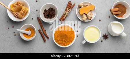 Goldene Milch mit Zimt, Honig, Curkuma-Wurzel und Kurkuma-Pulver Stockfoto