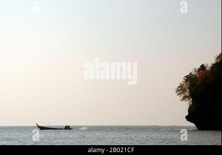 Thailand: Silhouette eines Langboot im Ao Phang Nga (Phangnga Bay) Nationalpark, Provinz Phang Nga. Der Ao Phang Nga Nationalpark wurde 1981 eröffnet und umfasst eine Fläche von etwa 400 km² und besteht hauptsächlich aus Karstfelsen und Inseln, hoch aufragenden Klippen und dem klaren Wasser des Phuket-Meeres. Obwohl die Heimat einer Vielzahl von Meeres- und Küstenbewohnern, einschließlich des zwei Meter langen Wasserüberwachungssystems, besuchen die meisten Menschen den Park, um die vielen aufragenden Karsttürme zu bewundern und zu segeln. Stockfoto