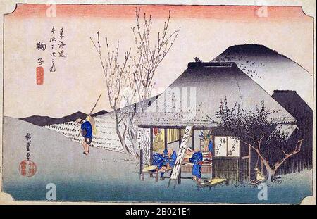 Japan: Station Twenty: The Famous Teahouse at Mariko. Ukiyo-e-Holzschnitt aus der Serie „Three Stations of the Tôkaidô Road“ von Utagawa Hiroshige (1797-1858), um 1834. Mariko: Zwei Reisende, die sich in einem Teehaus am Wegrand erfrischen, von dem gerade ein anderer Reisende abgereist ist, und eine Frau mit einem Kind auf dem Rücken, die auf sie wartet. Neben dem Teehaus wächst ein Pflaumenbaum, der gerade vor dem rosafarbenen Himmel in Blüte bricht; dahinter erhebt sich ein grauer, braun gefärbter Hügel. Hier genießen Reisende geriebene Yamsbrühe, die lokale Spezialität, während sie die grünen Blätter und Pflaumenblüten bewundern. Stockfoto