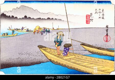 Mitsuke: Eine große Sandbank im Zentrum des "Heaven-dragon"-Flusses und Menschen, die den weiteren Arm in Booten überqueren; zwei weitere Boote im Vordergrund, zum Sandufer hin vermocht und das ferne Ufer von Nebel umhüllt. Der Name dieser Station wurde dadurch abgeleitet, dass die von Kyoto nach Edo Reisenden Menschen von hier aus ihren ersten Blick auf den Fuji erhalten konnten. Der schnell fließende Fluss "Tenryu" floss westlich des Bahnhofs und Reisende mussten den Fluss mit dem Fährschiff überqueren. Utagawa Hiroshige (歌川 広重, * um die Welt der Künstler) (* um die Welt der  ; † 12. Oktober 1858) war ein japanischer Ukiyo-e-Künstler und einer der letzten großen Künstler Stockfoto
