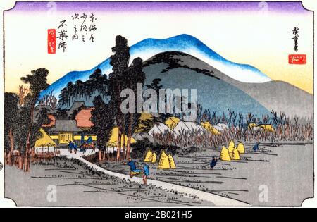 Japan: Station Vierundvierzig: Ishiyakushi-Tempel. Ukiyo-e-Holzschnitt aus der Serie „Three Stations of the Tôkaidô Road“ von Utagawa Hiroshige (1797-1858), um 1834. Ishiyakushi: Ein Tempel in einem Baumhain auf der linken Seite und das Dorf auf der rechten Seite; dahinter ein hohes Gebirge von Hügeln, gedruckt aus Farbblöcken. Diese Station entstand um einen alten Tempel in friedlicher und ruhiger ländlicher Umgebung. Im Tempel Ishiyakushi wurde ein Steinbild von Buddha Yakushi verwahrt, das von vielen Gläubigen besucht wurde. Stockfoto