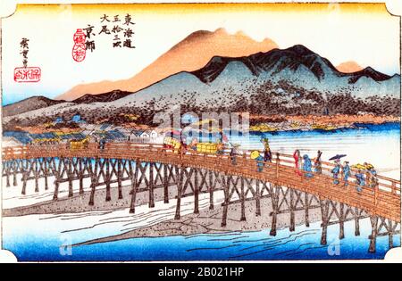 Japan: Keishi (Kyoto): Die Große Sanjo-Brücke. Ukiyo-e-Holzschnitt aus der Serie „Three Stations of the Tôkaidô Road“ von Utagawa Hiroshige (1797-1858), um 1834. Kyoto: Im Vordergrund die „lange“ Brücke über den Kamo-Fluss, und die Menschen überqueren, mit der Stadt dahinter, hinter der sich Hügel erheben, die den Kamo-Fluss überblicken, die entfernteste Druckschrift nur aus abgestuften Farbblöcken. Während der Abfahrt nach Kyoto konnten Reisende vom Bergpass aus einen Panoramablick auf die elegante kaiserliche Hauptstadt genießen und hatten zweifellos Freude und Erleichterung, als sie das letzte Ziel ihrer Reise von Edo aus sahen. Stockfoto