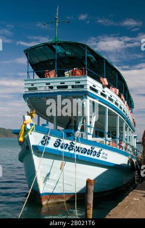 Thailand: Tauchboot am Pier, Bang Bao Fischerdorf, Ko Chang, Provinz trat. In einem Land, das mit einer Fülle von wunderschönen Inseln gesegnet ist, ist Ko Chang eine der schönsten. Es ist auch Thailands zweitgrößte Insel (nach Phuket), aber was sie so attraktiv macht, ist ihr rauer Aspekt und die Art, wie sie plötzlich aus dem Meer steigt, die üblichen schönen weißen Sandstrände Thailands, die aber von einem soliden hügeligen Innern umgeben sind, das von wildem Dschungel bedeckt ist, der die Küste vor dem Meer zu schützen scheint. Die Leute besuchen Ko Chang wegen dieser unberührten Strände. Stockfoto