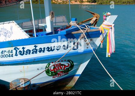 Thailand: Tauchboot am Pier, Bang Bao Fischerdorf, Ko Chang, Provinz trat. In einem Land, das mit einer Fülle von wunderschönen Inseln gesegnet ist, ist Ko Chang eine der schönsten. Es ist auch Thailands zweitgrößte Insel (nach Phuket), aber was sie so attraktiv macht, ist ihr rauer Aspekt und die Art, wie sie plötzlich aus dem Meer steigt, die üblichen schönen weißen Sandstrände Thailands, die aber von einem soliden hügeligen Innern umgeben sind, das von wildem Dschungel bedeckt ist, der die Küste vor dem Meer zu schützen scheint. Die Leute besuchen Ko Chang wegen dieser unberührten Strände. Stockfoto