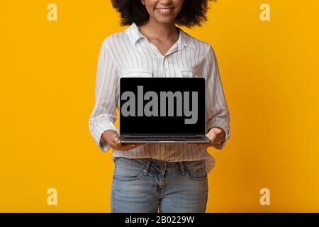 Laptop-Computer Mit Schwarzem Bildschirm In Den Händen Einer Nicht Erkennbaren Schwarzen Frau Stockfoto