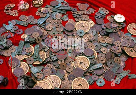 China: Alte Münzen zum Verkauf auf einem Markt in Quanzhou, Provinz Fujian. Quanzhou wurde 718 während der Tang-Dynastie (618–907) gegründet. Damals war Guangzhou Chinas größter Seehafen, aber dieser Status wurde später von Quanzhou übertroffen. Während der Song-Dynastie (960–1279) und der Yuan-Dynastie (1279–1368) war Quanzhou einer der größten Seehäfen der Welt und beherbergte eine große Gemeinschaft ausländischer Einwohner aus der ganzen eurasischen Welt. Stockfoto