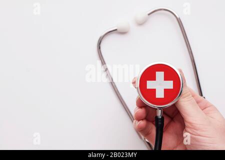 Gesundheitskonzept Schweiz. Arzt, der ein medizinisches Stethoskop hält. Stockfoto