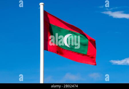 Malediven: Maledivische Flagge, Addu-Atoll (Seenu-Atoll). Asiens kleinste und am wenigsten bekannte Nation, die Republik Malediven, liegt von Norden nach Süden auf einem 750 Kilometer langen Indischen Ozean, 500 Kilometer südwestlich von Sri Lanka. Mehr als 1000 Inseln, zusammen mit unzähligen Ufern und Riffen, gruppieren sich in einer Kette von 19 Atollen, die sich von einem Punkt genau westlich von Colombo bis kurz südlich des Äquators erstreckt. Die Atolle, die aus großen Korallenringen auf der Basis des U-Bootes Laccadive-Chagos gebildet sind, variieren stark in ihrer Größe. Stockfoto