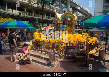 Thailand: Erawan-Schrein (San Phra Phrom), Bangkok. Der Erawan-Schrein, unter der Chit Lom Skytrain Station in Bangkok, repräsentiert den vierköpfigen hinduistischen gott der Schöpfung, Brahma (Phra Phrom), und wurde 1956 nach einer Reihe tödlicher Unglücksfälle errichtet, die den Bau des ursprünglichen Erawan Hotels betrafen. Brahmā ist der hinduistische gott der Schöpfung und einer der Trimūrti, die anderen sind Vishnu und Shiva. Der Brahmā Purāņa zufolge ist er der Vater von Manu, und aus Manu sind alle Menschen abstammen. In der Rāmāyaņa und der Mahābhārata wird er als Nachkomme aller Menschen bezeichnet. Stockfoto