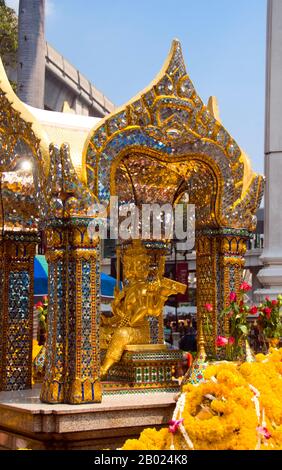 Thailand: Erawan-Schrein (San Phra Phrom), Bangkok. Der Erawan-Schrein, unter der Chit Lom Skytrain Station in Bangkok, repräsentiert den vierköpfigen hinduistischen gott der Schöpfung, Brahma (Phra Phrom), und wurde 1956 nach einer Reihe tödlicher Unglücksfälle errichtet, die den Bau des ursprünglichen Erawan Hotels betrafen. Brahmā ist der hinduistische gott der Schöpfung und einer der Trimūrti, die anderen sind Vishnu und Shiva. Der Brahmā Purāņa zufolge ist er der Vater von Manu, und aus Manu sind alle Menschen abstammen. In der Rāmāyaņa und der Mahābhārata wird er als Nachkomme aller Menschen bezeichnet. Stockfoto