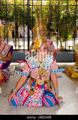 Thailand: Traditionelle thailändische Tänzer am Erawan-Schrein (San Phra Phrom), Bangkok. Der Erawan-Schrein, unter der Chit Lom Skytrain Station in Bangkok, repräsentiert den vierköpfigen hinduistischen gott der Schöpfung, Brahma, und wurde 1956 nach einer Reihe tödlicher Unglücksfälle errichtet, die den Bau des ursprünglichen Erawan Hotels erlitten hatten. Traditionelle thailändische Tänzer, die sich dauerhaft am Schrein befinden, werden angeheuert, um von Gläubigen zu tanzen, als Gegenleistung dafür, dass sie ihre Gebete am Schrein erhört haben. Stockfoto