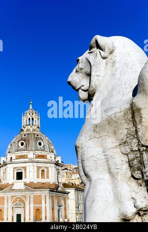 Geflügelte Löwe Skulptur, Denkmal Victor Emmanuel II. Altar des Vaterlandes. Im Hintergrund Kuppel der Kirche Heilige Maria von Loreto. Rom. Nahaufnahme Stockfoto