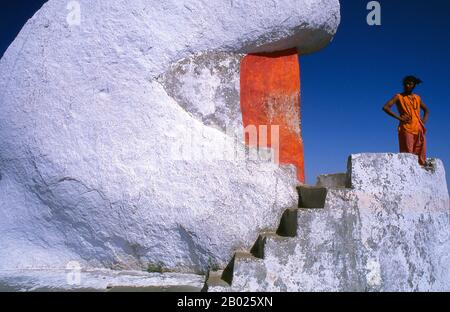 Indien: Ein Swami untersucht die Szene aus seiner Eremitage, Mount Abu, Rajasthan. Ein Swai ist ein Asket oder Yogi, der in den von Adi Shankara gegründeten religiösen Orden eingeweiht wurde. Mount Abu ist eine beliebte Bergstation in der Aravalli Range im Bezirk Sirohi im Bundesstaat Rajasthan in Westindien nahe der Grenze zu Gujarat. Der Berg bildet ein ausgeprägtes Felsplateau von 22 km Länge und 9 km Breite. Der höchste Gipfel des Berges ist Guru Shikhar mit 1.722 m (5.650 ft) über dem Meeresspiegel. Es wird als „eine Oase in der Wüste“ bezeichnet. Stockfoto