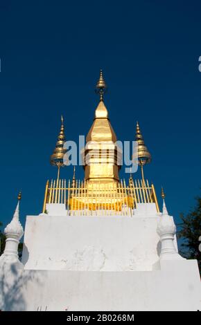 Laos: Diese Chomsi (Chomsi Stupa) auf dem Gipfel des Phousi (Phu Si) Hill, Luang Prabang. Phousi, ein felsiger 100 Meter (330ft m) langer Hügel, dominiert das Zentrum von Luang Prabang. An seinen Füßen steht Wat Paa Huak. Von diesem Tempel aus enden 328 Stufen bis zu dem 24 Meter (79ft m) langen Chom Si auf dem Gipfel, der eine beeindruckende vergoldete Stupa in klassischer Lao-Form hat. Luang Prabang war früher die Hauptstadt eines Königreichs mit demselben Namen. Bis zur kommunistischen Machtübernahme im Jahr 1975 war es die königliche Hauptstadt und der Sitz der Regierung des Königreichs Laos. Die Stadt gehört heute zum UNESCO-Weltkulturerbe. Stockfoto