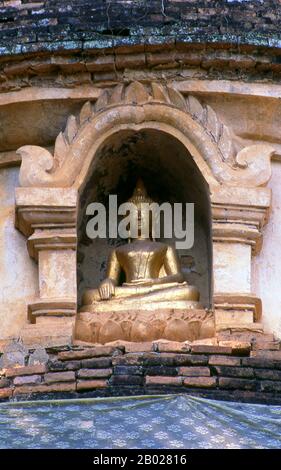Thailand: Detail von Buddha in Nische, alte Chedi im Wat Rampoeng Tapotharam, Chiang Mai, Nord-Thailand. 1487 starb König Tilokarat, 9. Der Mangrai-Monarchen, und überließ den Thron seinem Enkel, König Yot Chiang Rai (1487–1495). Laut der Yonok Chronicle wanderte während der Regierungszeit von Yot Chiang Rai ein Mönch durch den Wald zwischen Chiang Mai City und Doi Suthep, als er wundersame Lichtstrahlen vom Boden unter einem großen, alten Baum sah. Als er davon erfuhr, war König Yot Chiang Rai neugierig und machte sich auf den Elefanten zurück, um zu untersuchen. Stockfoto