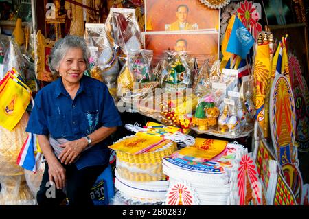 Thailand: Eine thailändische Frau verkauft königliche Gegenstände, einschließlich gelber königlicher Flaggen für König Bhumibol (Rama IX) in Banglamphu, Bangkok. Bhumibol Adulyadej (Phumiphon Adunyadet; 5. Dezember 1927 - 13. Oktober 2016) war der König von Thailand. Er war bekannt als Rama IX (und innerhalb der thailändischen Königsfamilie und enger Partner einfach als Lek. Seit dem 9. Juni 1946 regierte er als der längste regierende Monarch der thailändischen Geschichte. Stockfoto