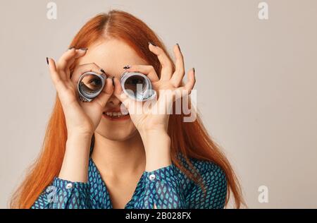 Frau, die mit Dollarscheinen durch Röhrchen schaut. Konzept der Merkantizität Stockfoto