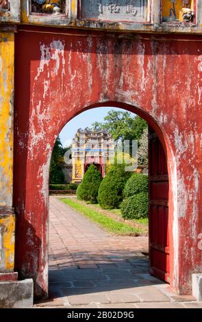 Vietnam: Tore, die in den Thế Miếu (den Mieu) Ahnentempel führen, die Kaiserstadt, die Zitadelle, Hue. Der Thế Miếu, auch Thế Tổ Miếu genannt, ist ein Ahnentempel und wurde 1822–1823 auf Befehl von Kaiser Minh Mạng errichtet. Er ehrt die Kaiser der Nguyễn-Dynastie. Neun dynastische Urnen (Vietnamesisch cửu đỉnh) vor dem Thế Miếu wurden ebenfalls 1822 gegossen und den ersten neun Kaisern der Nguyen gewidmet. Kaiser Gia Long ordnete 1805 den Bau der Zitadelle von Hue an. Der riesige Komplex wurde nach den Vorstellungen von Fengshui oder chinesischer Geomanz gebaut. Stockfoto
