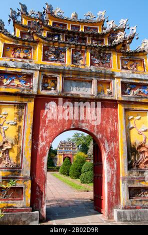 Vietnam: Tore, die in den Thế Miếu (den Mieu) Ahnentempel führen, die Kaiserstadt, die Zitadelle, Hue. Der Thế Miếu, auch Thế Tổ Miếu genannt, ist ein Ahnentempel und wurde 1822–1823 auf Befehl von Kaiser Minh Mạng errichtet. Er ehrt die Kaiser der Nguyễn-Dynastie. Neun dynastische Urnen (Vietnamesisch cửu đỉnh) vor dem Thế Miếu wurden ebenfalls 1822 gegossen und den ersten neun Kaisern der Nguyen gewidmet. Kaiser Gia Long ordnete 1805 den Bau der Zitadelle von Hue an. Der riesige Komplex wurde nach den Vorstellungen von Fengshui oder chinesischer Geomanz gebaut. Stockfoto