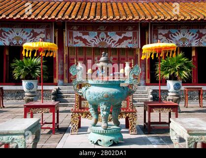 Vietnam: Thế Miếu (der Mieu) Ahnentempel, die Kaiserstadt, die Zitadelle, Hue. Der Thế Miếu, auch Thế Tổ Miếu genannt, ist ein Ahnentempel und wurde 1822–1823 auf Befehl von Kaiser Minh Mạng errichtet. Er ehrt die Kaiser der Nguyễn-Dynastie. Neun dynastische Urnen (Vietnamesisch cửu đỉnh) vor dem Thế Miếu wurden ebenfalls 1822 gegossen und den ersten neun Kaisern der Nguyen gewidmet. Kaiser Gia Long ordnete 1805 den Bau der Zitadelle von Hue an. Der riesige Komplex wurde nach den Vorstellungen von Fengshui oder chinesischer Geomanz gebaut. Stockfoto