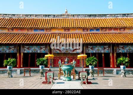 Vietnam: Thế Miếu (der Mieu) Ahnentempel, die Kaiserstadt, die Zitadelle, Hue. Der Thế Miếu, auch Thế Tổ Miếu genannt, ist ein Ahnentempel und wurde 1822–1823 auf Befehl von Kaiser Minh Mạng errichtet. Er ehrt die Kaiser der Nguyễn-Dynastie. Neun dynastische Urnen (Vietnamesisch cửu đỉnh) vor dem Thế Miếu wurden ebenfalls 1822 gegossen und den ersten neun Kaisern der Nguyen gewidmet. Kaiser Gia Long ordnete 1805 den Bau der Zitadelle von Hue an. Der riesige Komplex wurde nach den Vorstellungen von Fengshui oder chinesischer Geomanz gebaut. Stockfoto