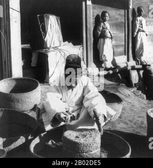 Korea: Bohnenmahlen auf einer Seoul-Straße, 1906. Seoul ist die Hauptstadt und größte Metropole Südkoreas. Eine Megacity mit mehr als 10 Millionen Einwohnern ist die größte Stadt der entwickelten Welt. Die Hauptstadt von Seoul, zu der auch die umliegende Metropole Incheon und die Provinz Gyeonggi gehören, ist mit über 25,6 Millionen Einwohnern die zweitgrößte Metropolregion der Welt. Sie beherbergt mehr als die Hälfte der Südkoreaner und 632.000 internationale Einwohner. Stockfoto