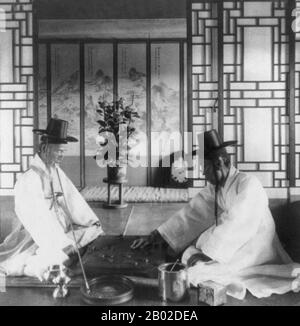 Korea: Zwei koreanische Kabinettsminister (Yun-Woong-Niel, Kriegsminister auf der linken Seite) spielen Baduk oder Go-Ban (orientalisches Schach) in einem Haus der Oberschicht, Seoul, um 1904. Seoul ist die Hauptstadt und größte Metropole Südkoreas. Eine Megacity mit mehr als 10 Millionen Einwohnern ist die größte Stadt der entwickelten Welt. Die Hauptstadt von Seoul, zu der auch die umliegende Metropole Incheon und die Provinz Gyeonggi gehören, ist mit über 25,6 Millionen Einwohnern die zweitgrößte Metropolregion der Welt. Sie beherbergt mehr als die Hälfte der Südkoreaner und 632.000 internationale Einwohner. Stockfoto