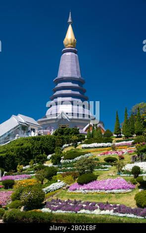 DOI Inthanon ist mit 2.595 Metern der höchste Berg Thailands. Benannt ist es nach Phra Inthawichayanon, dem letzten König von Chiang Mai, der um die Jahrhundertwende starb und dessen Überreste in einem kleinen weißen Chedi in der Nähe des Gipfels rot liegen. In der Nähe des Gipfels stehen zwei bemerkenswerte Chedis. Der erste ist der kupferfarbene Turmspitze von Phra Mahathat Chedi Nabhamethanidon, der von der Royal Thai Air Force zum Gedenken an den 60. Geburtstag von König Bhumibol erbaut und am 5. Dezember 1987 eingeweiht wurde. In der Nähe, aber mit lila statt mit Kupfer verkleidet, steht der weniger massive, aber elegantere Turmspitze von Phra Maha Stockfoto