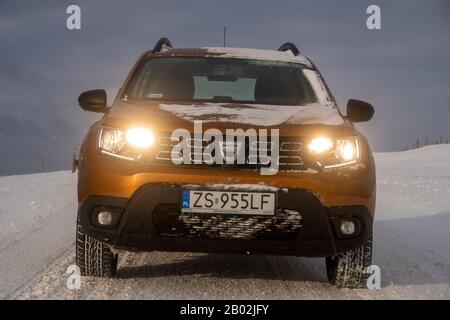 Dacia Duster SUV beim Fahren auf einer verschneiten Straße Stockfoto