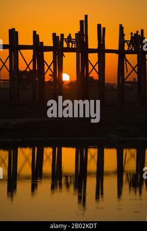 Fragment der U-Bein-Brücke im Hintergrund des Sonnenuntergangs. Amarapura, Myanmar (Birma) Stockfoto