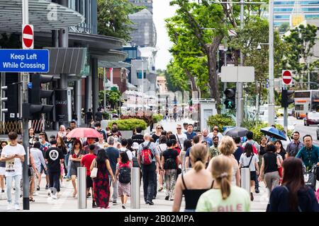 Belebte Straßenszenen von Menschen, die die Straße an der Orchard Road, Singapur, überqueren Stockfoto