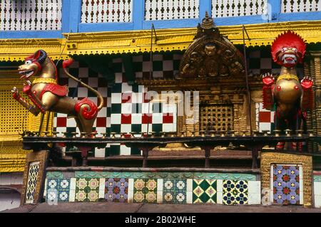 Bei Indra Chowk oder dem "Innenhof von Indra", einem zweistöckigen Tempel, der einer der 64 Formen des Bhairav gewidmet ist, blickt Akash Bhairav (Bhairav der Luft) über die Kreuzung mehrerer Fahrspuren. Der Tempel ist mit einer silbernen Statue von Akash Bhairav bedeckt und teilweise mit Messingplatten und zwei Messinglöwen stehen Wache an der Tür. Während des Festivals von Indra Jatra wird eine große Maske von Akash Bhairav auf einem Schrein ausgestellt, der vor dem Tempel montiert wurde. Akash Bhairav gilt als Manifestation von Indra, dem regengott. Stockfoto