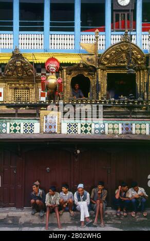 Bei Indra Chowk oder dem "Innenhof von Indra", einem zweistöckigen Tempel, der einer der 64 Formen des Bhairav gewidmet ist, blickt Akash Bhairav (Bhairav der Luft) über die Kreuzung mehrerer Fahrspuren. Der Tempel ist mit einer silbernen Statue von Akash Bhairav bedeckt und teilweise mit Messingplatten und zwei Messinglöwen stehen Wache an der Tür. Während des Festivals von Indra Jatra wird eine große Maske von Akash Bhairav auf einem Schrein ausgestellt, der vor dem Tempel montiert wurde. Akash Bhairav gilt als Manifestation von Indra, dem regengott. Stockfoto