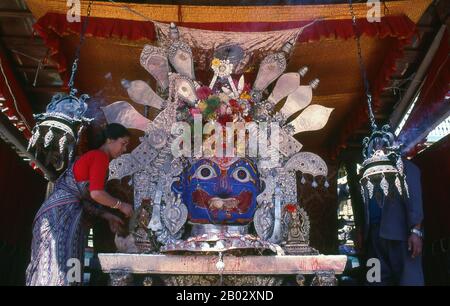 Bei Indra Chowk oder dem "Innenhof von Indra", einem zweistöckigen Tempel, der einer der 64 Formen des Bhairav gewidmet ist, blickt Akash Bhairav (Bhairav der Luft) über die Kreuzung mehrerer Fahrspuren. Der Tempel ist mit einer silbernen Statue von Akash Bhairav bedeckt und teilweise mit Messingplatten und zwei Messinglöwen stehen Wache an der Tür. Während des Festivals von Indra Jatra wird eine große Maske von Akash Bhairav auf einem Schrein ausgestellt, der vor dem Tempel montiert wurde. Akash Bhairav gilt als Manifestation von Indra, dem regengott. Stockfoto