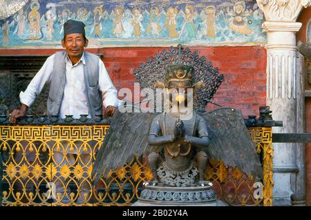 Rudravarna Mahavihara, oder Oku Bahal, wurde Mitte des 17. Jahrhunderts erbaut. Der Tempel befindet sich um einen Innenhof, der mit Chaitya- und Metallfiguren aller Art und Größen überströmt ist. Es gibt massive Garudas, Elefanten, Pfauen, Figuren betender Anbeter und eine Statue von Juddha Shamsher Rana, die dem Tempel nach dem Erdbeben von 1934 großzügige Wiederherstellungshilfen gewährt haben. In den Ecken des mit Öllampengeländern gesäumten Innenhofes befinden sich Bronzefiguren des boshaften affengottes Hanuman, die ihm beim Verzehr eines Kürbisses, einer Banane und etwas zeigen, das wie ein aussieht Stockfoto