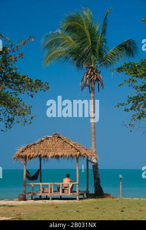Ko Phangan liegt 15 km nördlich von Ko Samui und 168 km2 (65 km2) etwa zwei Drittel seiner Größe. Die Insel hat dieselbe tropische Kombination aus weißen, sandigen Stränden, zugänglichen Korallenriffen und zerklüfteten, verjungfelten Innenräumen. Sobald die Hektierung von Budgetreisenden aus teureren Ko Samui entkommen ist, bewegt sie sich heute langsam weiter nach oben. Dennoch bleibt die Insel für den internationalen Tourismus viel weniger entwickelt als Ko Samui, was zum Teil auf ihre Isolation und zum Teil auf ihr schlechtes Infrastruktursystem zurückzuführen ist. Vor allem die Straßen bleiben arm, viele Orte entlang der Küste nur akzessi Stockfoto