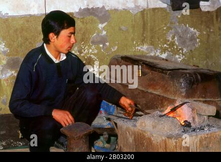Die kleine von Uiguren dominierte Oase Yengisar (Yingjisha) ist in der gesamten westchinesischen Provinz Xinjiang für die Herstellung von handgefertigten Messern bekannt. Die Kleine Messerfabrik (Pichak Chilik Karakhana/Xiadaochang) beschäftigt erfahrene Handwerker vor Ort, die feine Messer mit eingelegten Griffen herstellen. Fast jeder uigurische Mann trägt ein Messer, sowohl als Zeichen der Manschaft als auch für den utilitareren Zweck, Melonen aufzuschneiden, und die wertvollsten (und teuersten) stammen aus Yengisar. Stockfoto