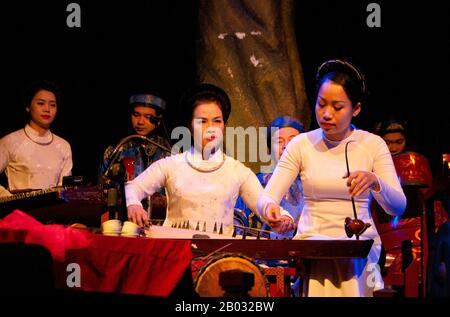 Water Puppetry oder Múa rối nước, wörtlich "Puppen, die auf Wasser tanzen", hat seinen Ursprung im Red River Delta. Die Marionetten sind aus wasserfestem Holz geschnitzt, um traditionelle ländliche Lebensstile und Fabelwesen darzustellen. Hinter der wässrigen Bühne, hüfttief im Wasser stehend, manövrieren die verborgenen Puppenspieler geschickt ihre Holzladen zur Musik eines traditionellen Orchesters. Stockfoto